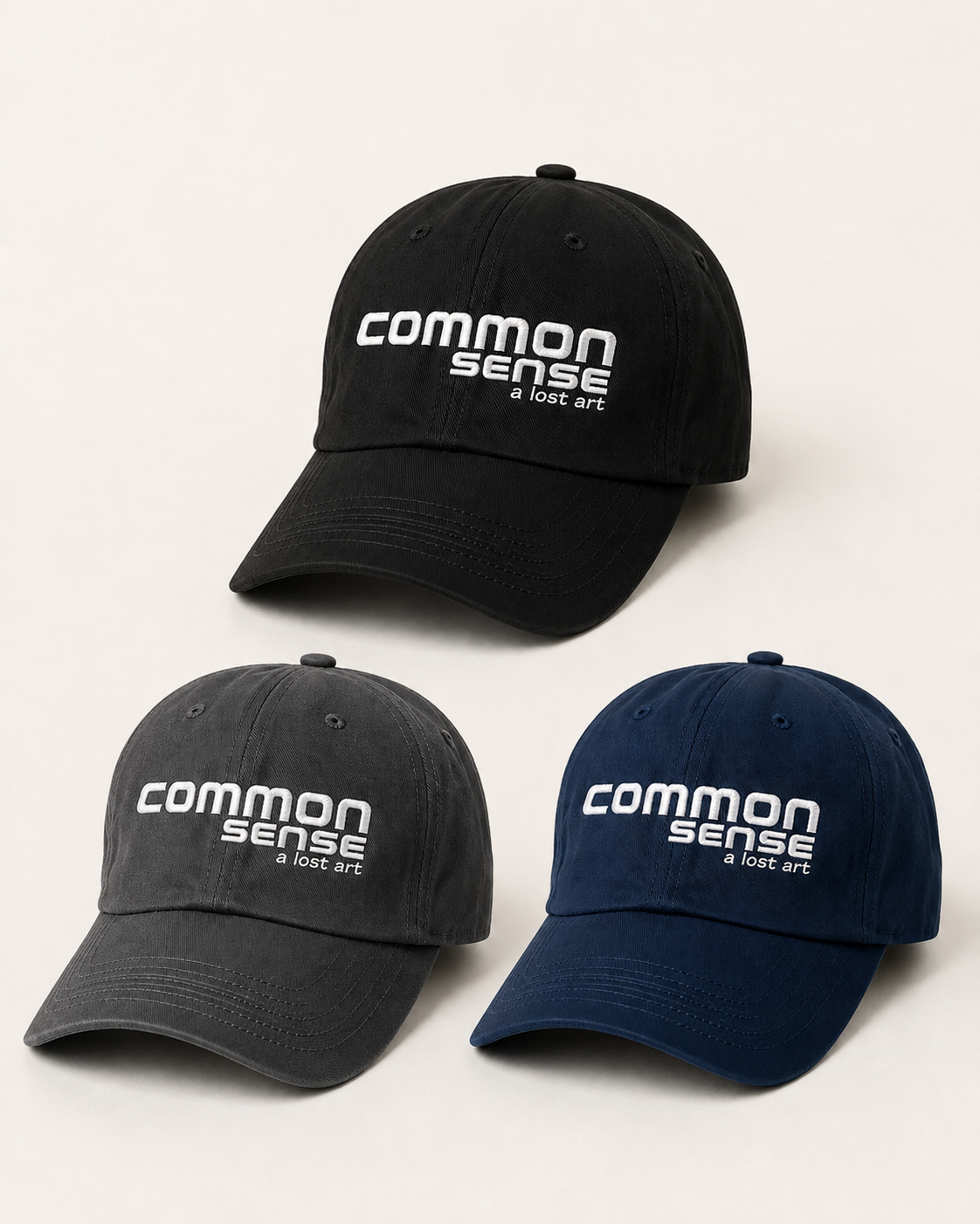 Three baseball caps arranged on a light neutral background: one black cap at the top, one dark gray cap at the lower left, and one navy cap at the lower right. Each cap has white embroidered text reading 'common sense' with smaller text below.