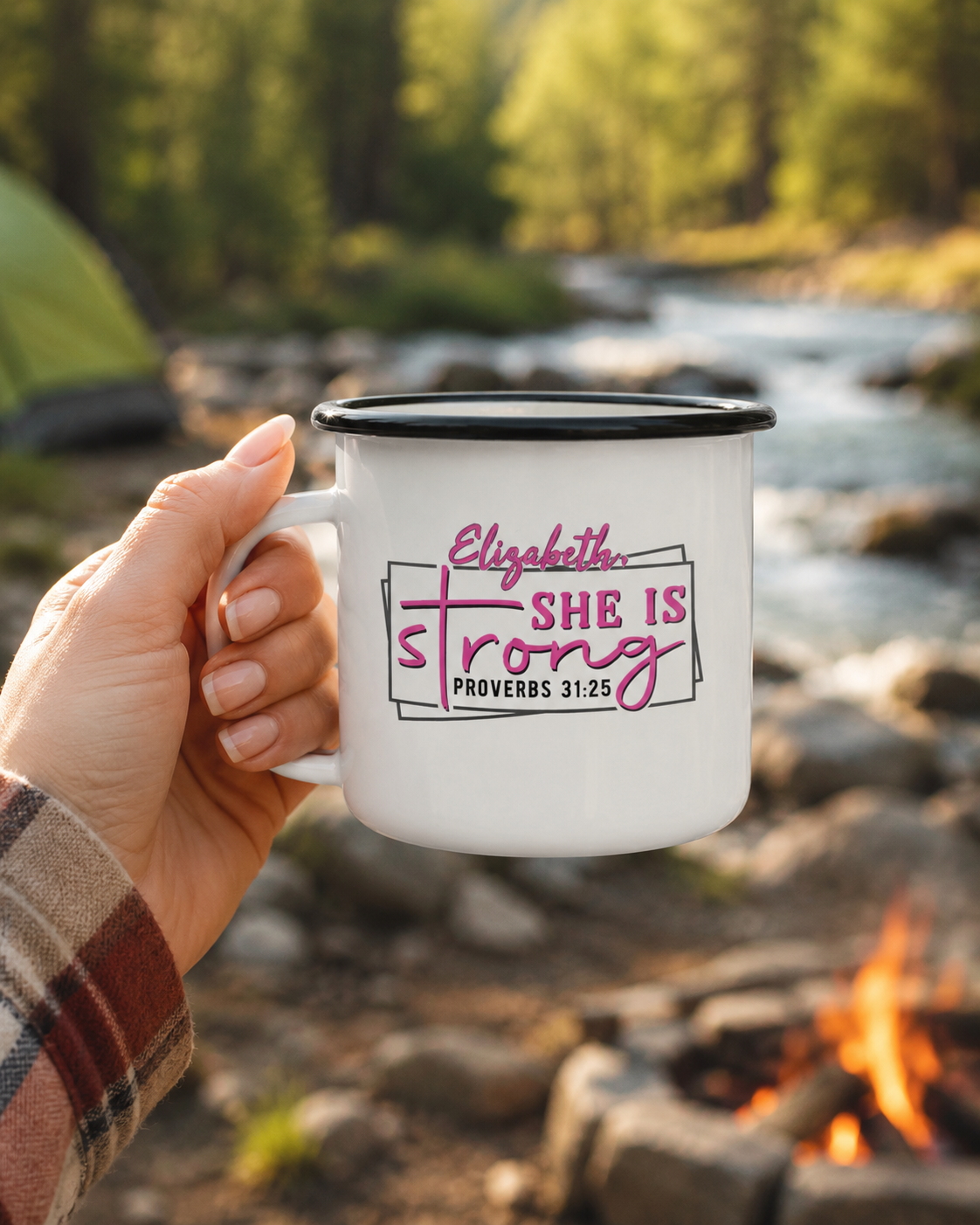 Woman holding a personalized Proverbs 31 enamel camp mug beside a creek and campsite