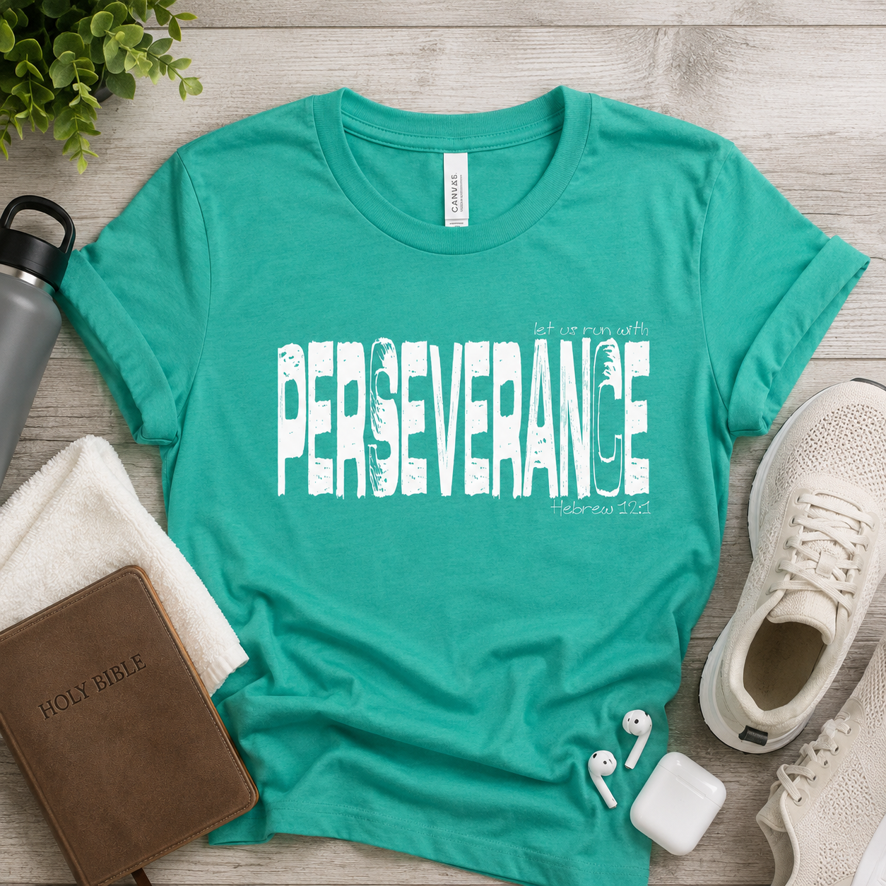 Teal Perseverance Christian T-shirt styled with a Bible, sneakers, water bottle, earbuds, and workout towel