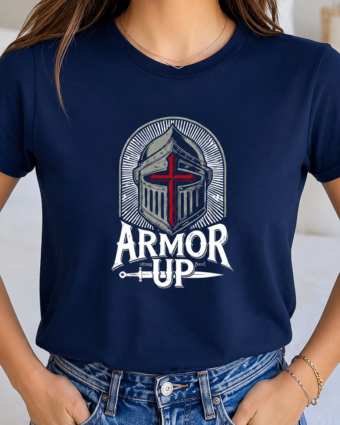 A woman wearing a navy blue graphic t-shirt with a white and red knight helmet design and the text 'ARMOR UP'.