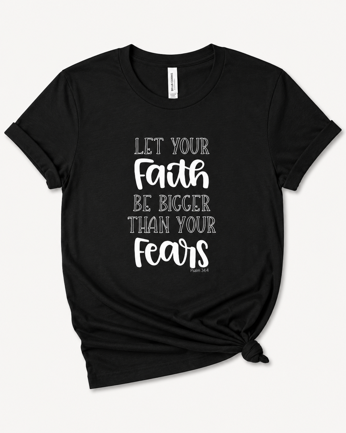 A black short-sleeve t-shirt with a white typographic print on the front reading 'LET YOUR Faith BE BIGGER THAN YOUR Fears' and a small 'Hebrews 6:18' reference. The t-shirt is styled with a knot at the bottom hem against a clean white background.