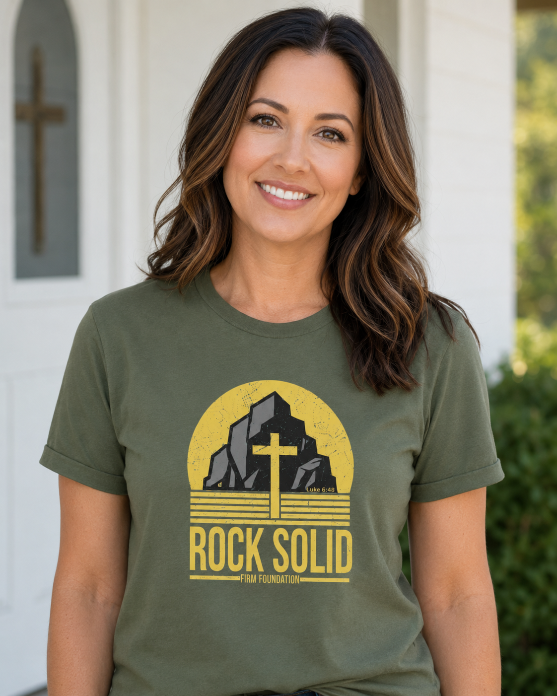 Woman wearing a military green Rock Solid Christian T-shirt with a faith-inspired firm foundation graphic